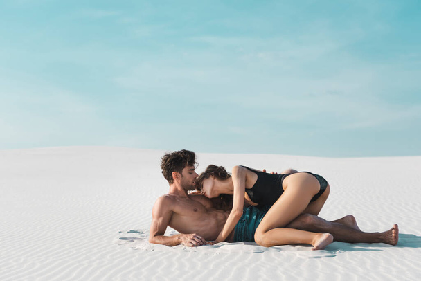 vista lateral de sexy jovem mulher no namorado na praia de areia
 - Foto, Imagem