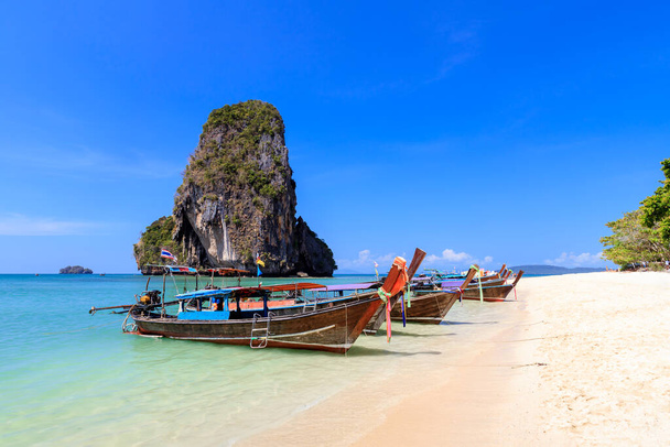 Long tail boat and turquoise crystal clear sea water with limestone cliff and mountain at Phra Nang Beach, Krabi, Thailand - Photo, Image