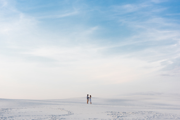 couple debout sur la plage de sable avec ciel bleu
 - Photo, image