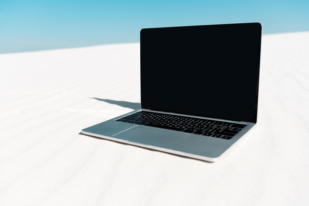青い空を背景に砂浜に白いスクリーンがあるノートパソコン - 写真・画像