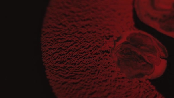 Espalhando a pintura vermelha no preto na água
 - Filmagem, Vídeo