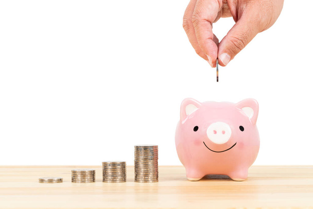 Свинка банк и стопка монет с руки положить деньги, на белом фоне
 - Фото, изображение