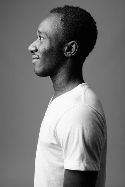 Studio shot of young African man in casual clothes against gray background in black and white - Fotoğraf, Görsel