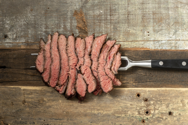 Scheiben eines Steaks auf Holz  - Foto, Bild