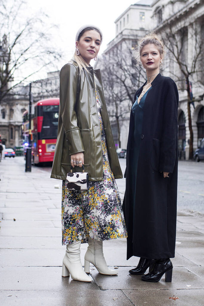 LONDON, UK- febryary 15 2020: Fashionable people on the street . Street style. Two girls friend in long dress - Fotó, kép
