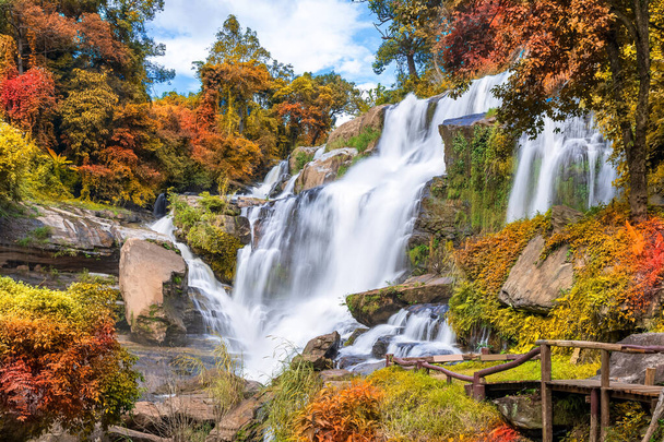 Colorful majestic waterfall in national park forest during autumn - Photo, Image