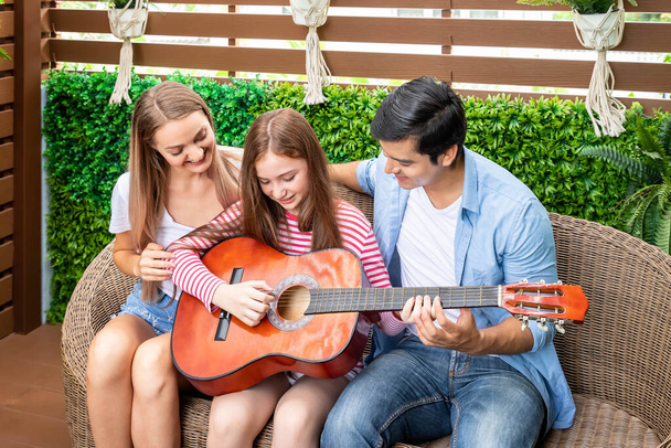 Ευτυχισμένη οικογένεια τραγουδά, και να απολαύσετε μουσική στον κήπο στο σπίτι. Μπαμπά! - Φωτογραφία, εικόνα