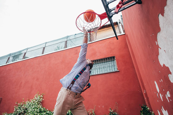 Young mixed race man outdoor dunking playing basketball - sportive, relaxing, success concept - Foto, Imagem