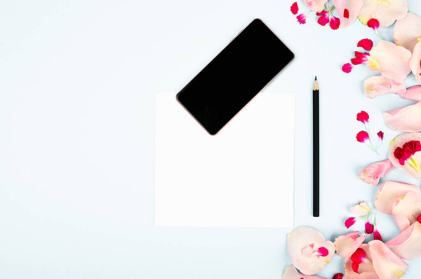 Imagen para el blog de mujeres. Colocación plana con flores, cuaderno, smartphone y lápiz sobre fondo de papel
. - Foto, Imagen