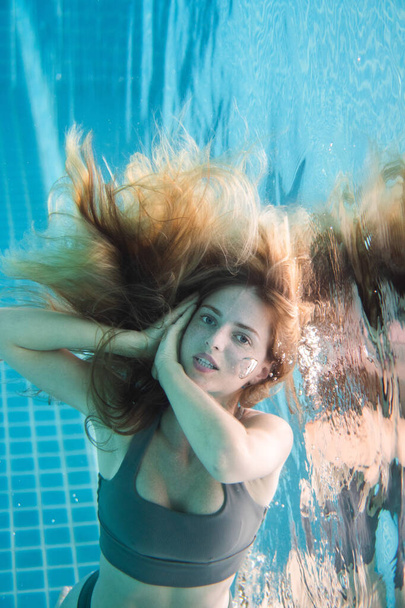 Bella donna con lunghi capelli rossi in posa sott'acqua in bikini
 - Foto, immagini