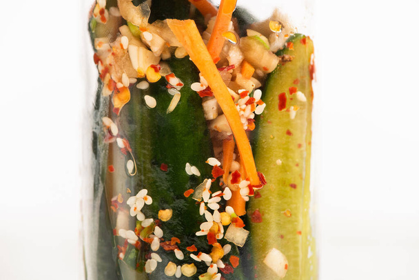 close up από νόστιμα kimchi αγγούρι σε γυάλινο βάζο που απομονώνονται σε λευκό - Φωτογραφία, εικόνα