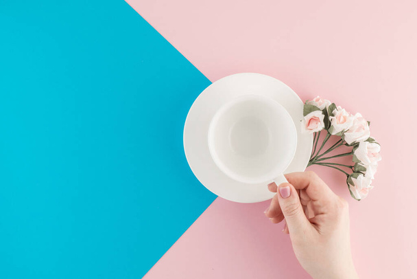 Empty coffee cup and flower on beautiful pink and bright blue pastel background. Top view. Flat lay. Template for design. - Foto, Imagem