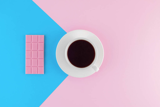 A cup of freshly brewed coffee on beautiful pink and bright blue pastel background. Fresh desserts. Meringue. Pink Chocolate. Top view. Flat lay.  - Foto, Bild