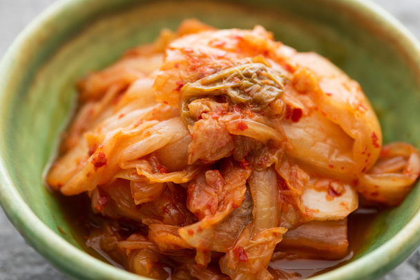 Nahaufnahme von schmackhaften Kohl-Kimchi in grüner Schüssel - Foto, Bild