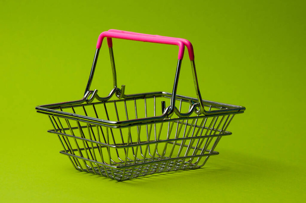 Корзина покупок на зеленом фоне. Концепция цен на продукты питания в супермаркете, скидки
 - Фото, изображение