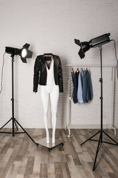 Stylish clothes on ghost mannequin and professional lighting equipment in modern studio. Fashion photography - 写真・画像