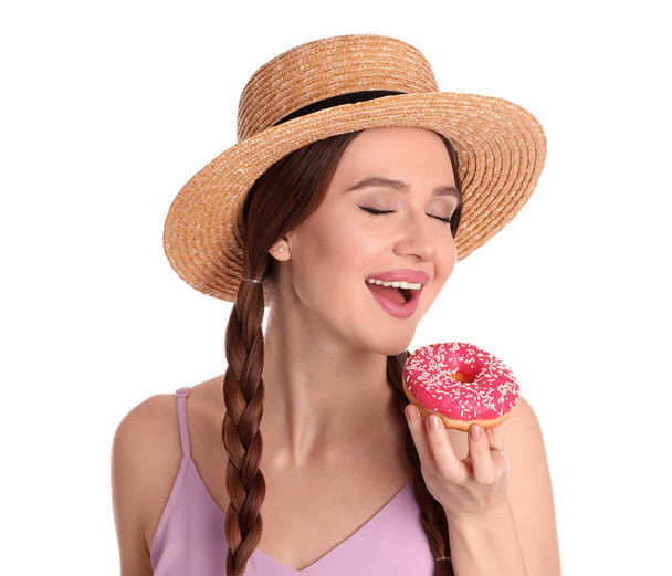 Beautiful young woman wearing stylish hat with donut on white background - Foto, immagini