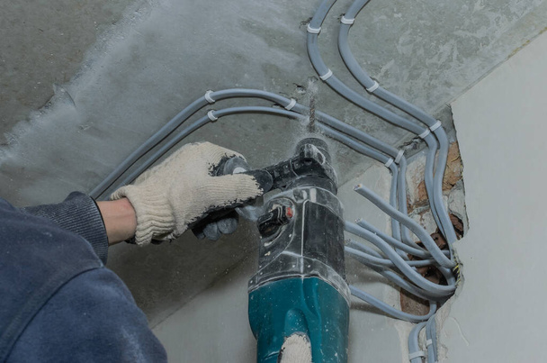 Worker drills a concrete wall with a hammer drill - Foto, Imagem