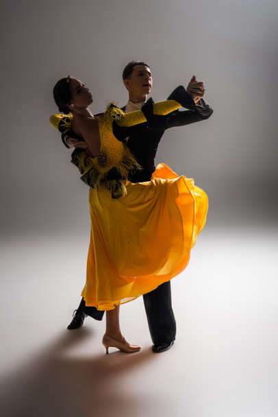 elegant young couple of ballroom dancers dancing in dark - Φωτογραφία, εικόνα