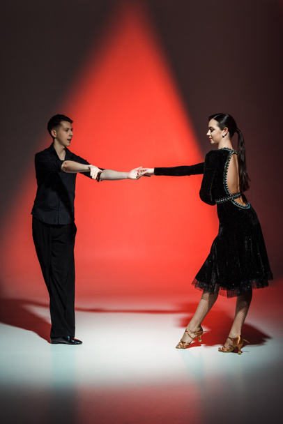 elegante giovane coppia di ballerini da sala che ballano a luci rosse
 - Foto, immagini