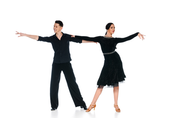 элегантная молодая пара танцовщиц в черном платье и костюме, танцующих изолированно на белом
 - Фото, изображение