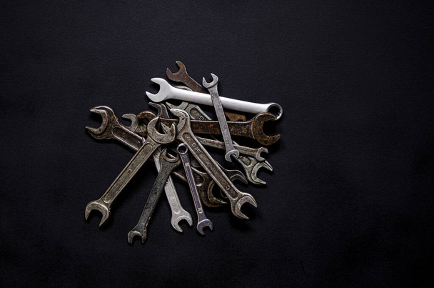 A set of repair tools in a leather case on a black background. Keys of different sizes - Zdjęcie, obraz
