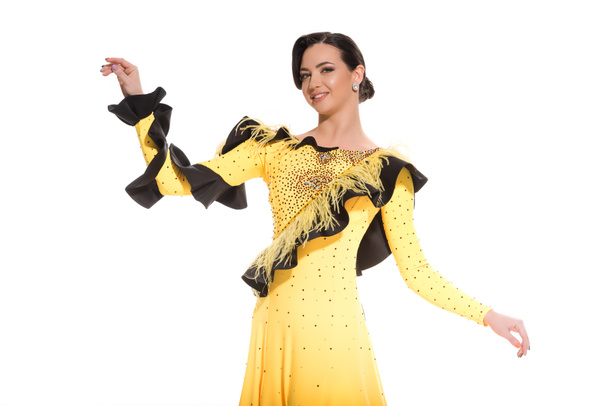 smiling elegant young ballroom dancer in yellow dress dancing isolated on white - 写真・画像