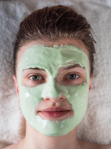 Gezicht van jonge aantrekkelijke vrouw met algen cosmetische masker close-up - cosmetische ingrepen - Foto, afbeelding