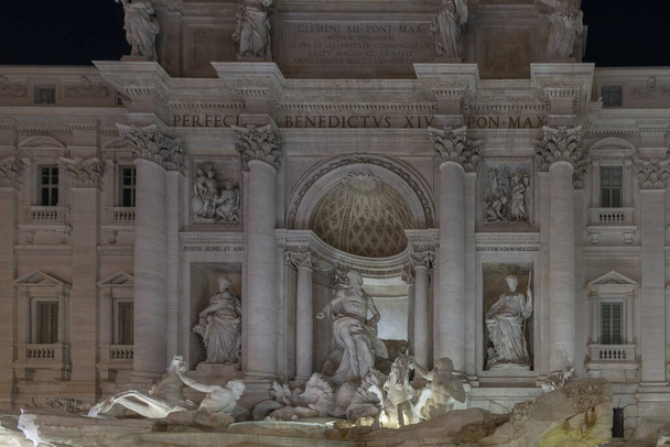 Nocne zdjęcie oświetlonej Fontanny di Trevi, Rzym, Włochy. Najsłynniejsza późnobarokowa rzymska fontanna. Rzeźby z białego marmuru w wodzie. - Zdjęcie, obraz