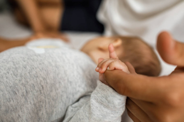 Closeup photo of littel baby's hand holding her father's finger. - Valokuva, kuva