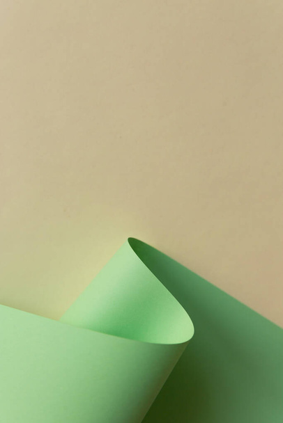 Diseño abstracto de onda de papel verde claro sobre fondo liso blanco amarillo natural. Moda tendencia neo menta color rollo
. - Foto, imagen
