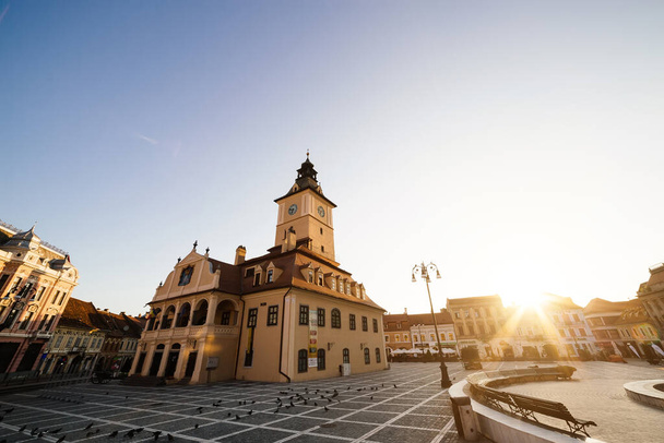 City central square (Piata Sfatului) with town council hall tower morning sunrise view, location Brasov, Transylvania, Romania. Famous travel destination summer postcard. - Fotó, kép