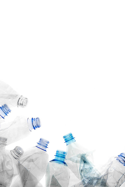 Leeg gedraaid gebruikt verlicht plastic flessen rand frame op witte achtergrond geïsoleerd. Milieuvervuiling conceptuele poster, banner template. - Foto, afbeelding