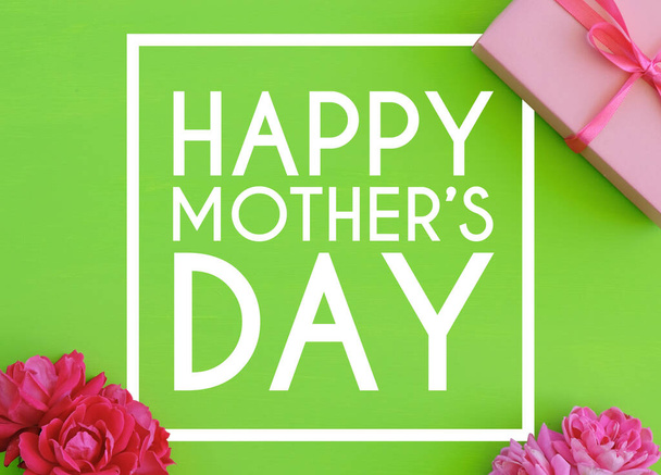 glücklicher Muttertagstext mit Rahmen und rosa Rosen, Geschenkbox auf grünem Hintergrund. - Foto, Bild