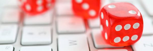 Červené kostky ležící na bílé klávesnici jako online kasino - Fotografie, Obrázek