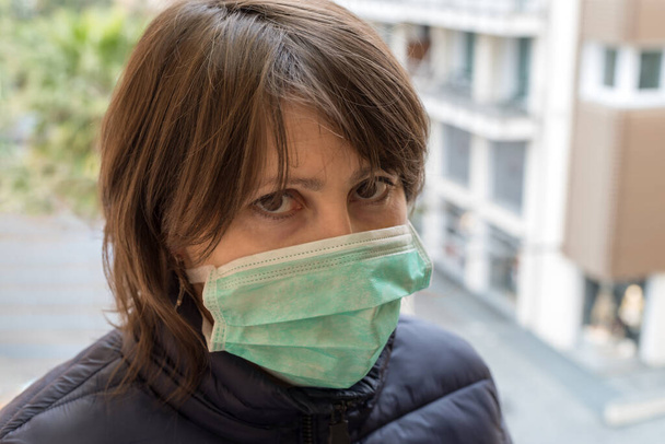 Προσωπογραφία ενήλικης γυναίκας με προστατευτική μάσκα στο στόμα της - Φωτογραφία, εικόνα