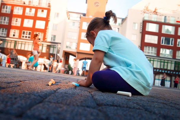 child draws with chalk on the pavement - Photo, Image