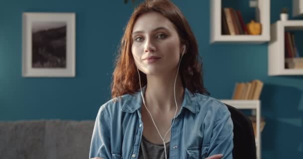 Portrait of beautiful woman listening music in earphones - Filmati, video