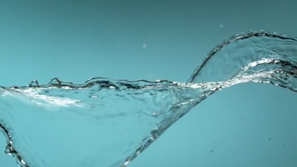 Szuper lassított felvétel fröccsenő víz elszigetelt kék háttérrel. Nagyon nagy sebességű kamerával filmezve, 1000 fps. - Felvétel, videó