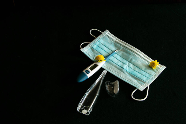 medisch masker en elektronische thermometer tijdens ziekte - Foto, afbeelding