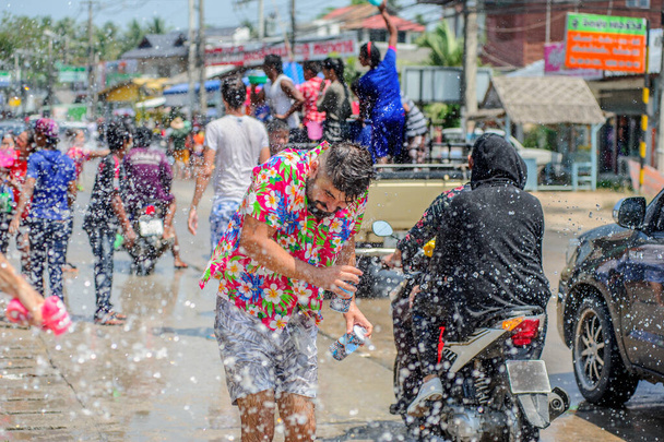 Thais en toeristen schieten waterpistolen, gieten water over elkaar, plezier hebben op Songkran festival, het traditionele Thaise Nieuwjaar - Foto, afbeelding