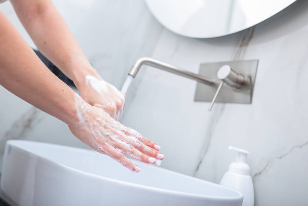 Γυναίκα πλένει τα χέρια με σαπούνι αφρού. Υγιεινή, πρόληψη του coronavirus και υγειονομική περίθαλψη - Φωτογραφία, εικόνα