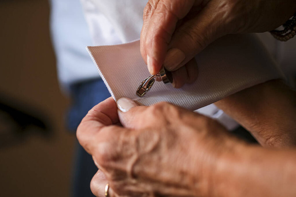 mother of the groom fastening cuffs and cufflinks before the wedding - 写真・画像