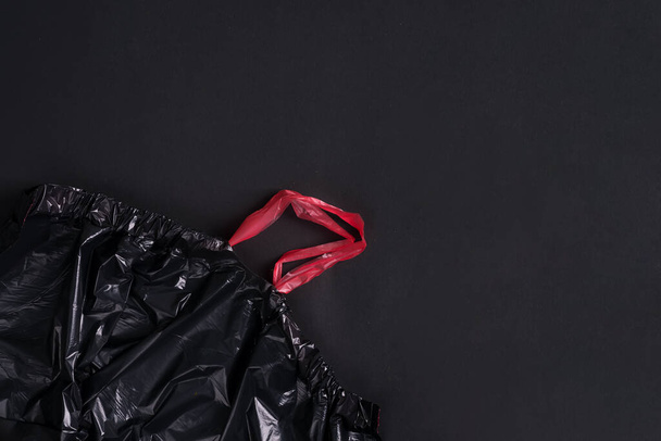 Plastic nieuwe lege wegwerp vuilniszakken op een zwarte achtergrond. Bovenaanzicht. - Foto, afbeelding