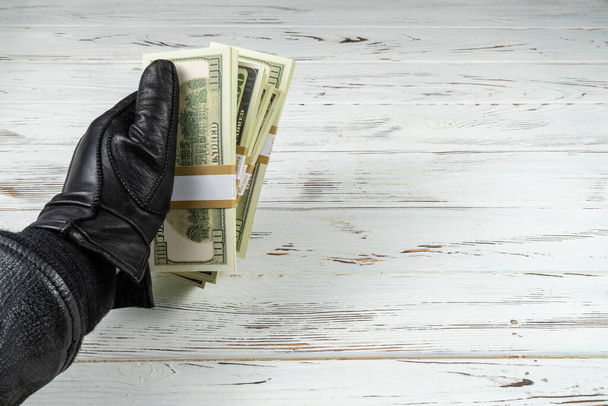 Crime Concept Homme en cuir noir gants tenant des briques d'argent
 - Photo, image