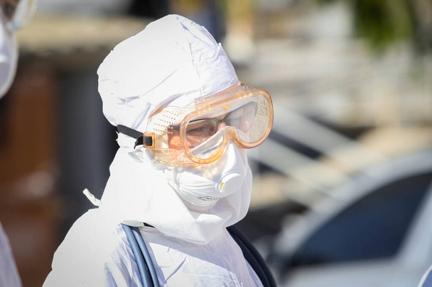 POLTAVA, UKRAINE - MARCH 12, 2020: Doctor in protective suit during coronavirus (COVID-19) attack in the afternoon - Foto, Bild