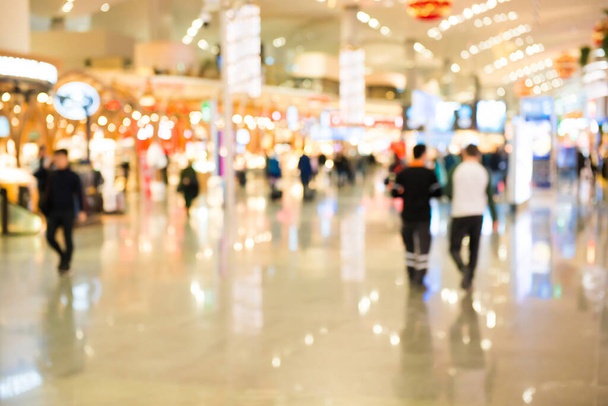 Zamazany tłum ludzi spacerujących w hali lotniskowej lub centrum handlowym - Zdjęcie, obraz
