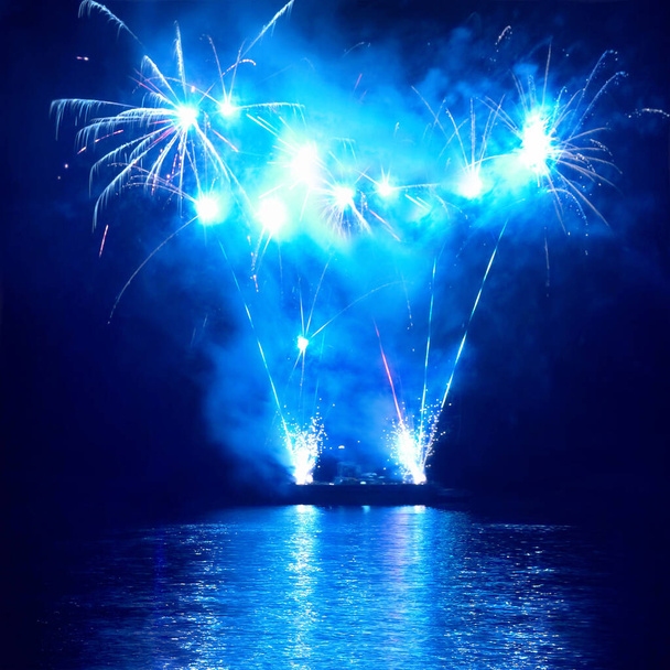 Fogos de artifício coloridos azuis no fundo do céu negro. Celebração de férias
. - Foto, Imagem