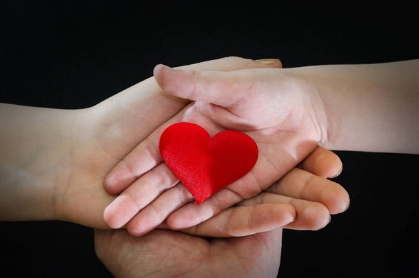 взрослые и дети руки держа красное сердце, здравоохранение, пожертвовать и семейное страхование концепции, всемирный день сердца, Всемирный день здоровья, концепция КСО, усыновление foster family.Image тонирована
 - Фото, изображение