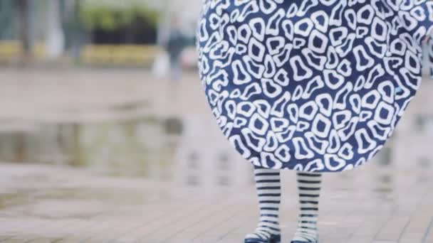 Κορίτσι με λαστιχένιες μπότες τρέχει και πηδάει σε μια λακκούβα - Πλάνα, βίντεο